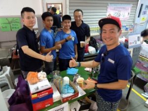 APSN Deputy CEO, Mr Gary Lim supporting students from APSN Katong School mending their drink stall with their instructors